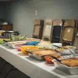 Long church fellowship hall table lined with potluck dishes, one unlabeled dish at the end